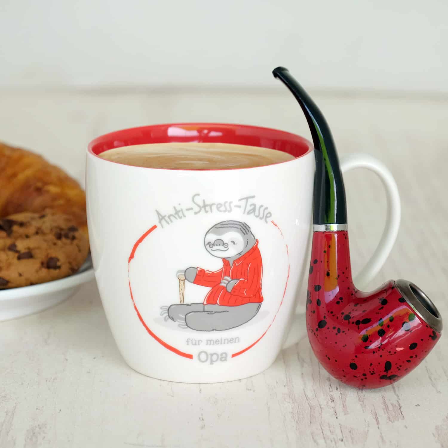 Weiße Tasse mit roten Akzenten, gefült mit Kaffee und dem Spruch "Anti-Stress-Tasse für meinen Opa" mit roten Akzenten