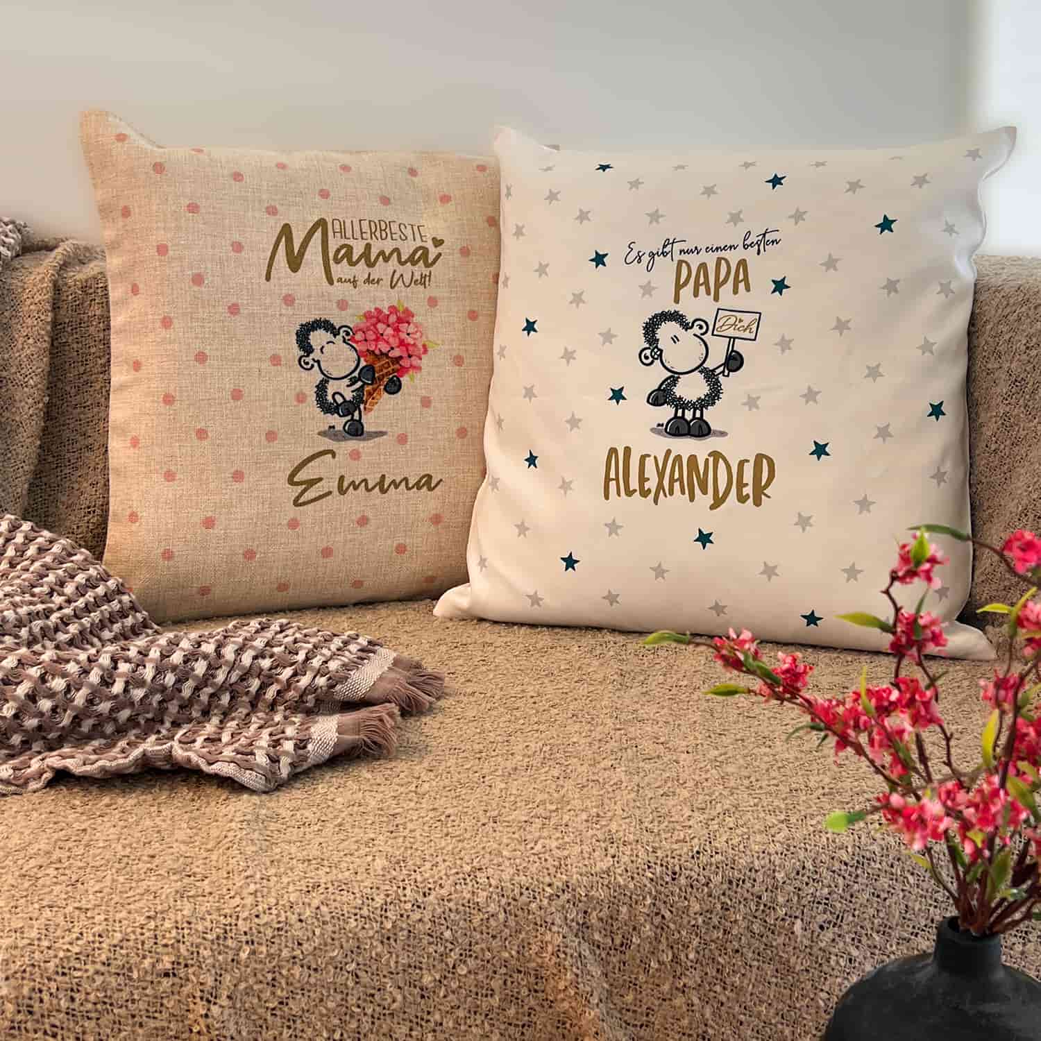 Zwei Personalisierte Kissen für Mama und Papa mit Emma und Alexander als Beispielsnamen auf einer Couch